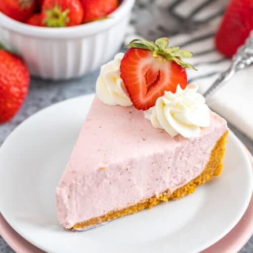 A slice of Strawberry Cheesecake on a white plate