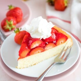 A slice of strawberry cake on a plate with a fork
