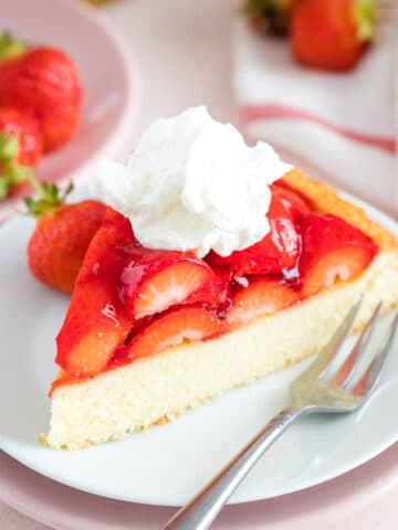 A slice of strawberry cake on a plate with a fork