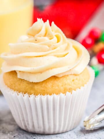 a frosted cupcake next to a piping bag