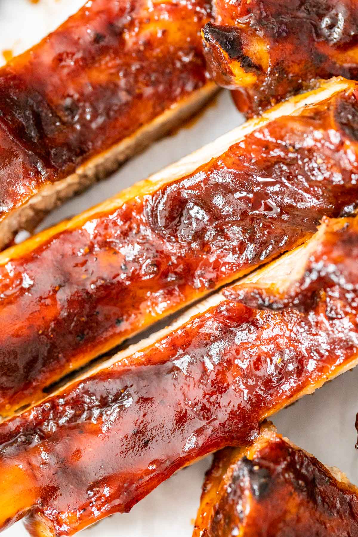 a close up of BBQ ribs on white parchment paper