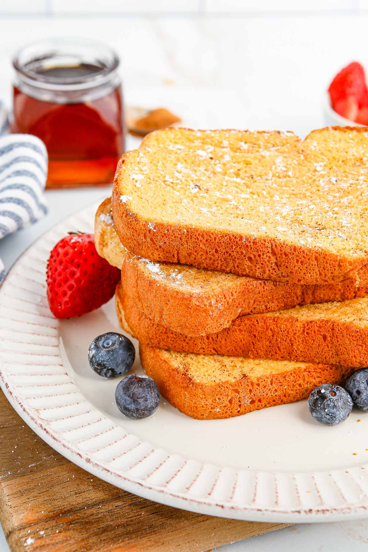 A stack of french toast on a white plate.