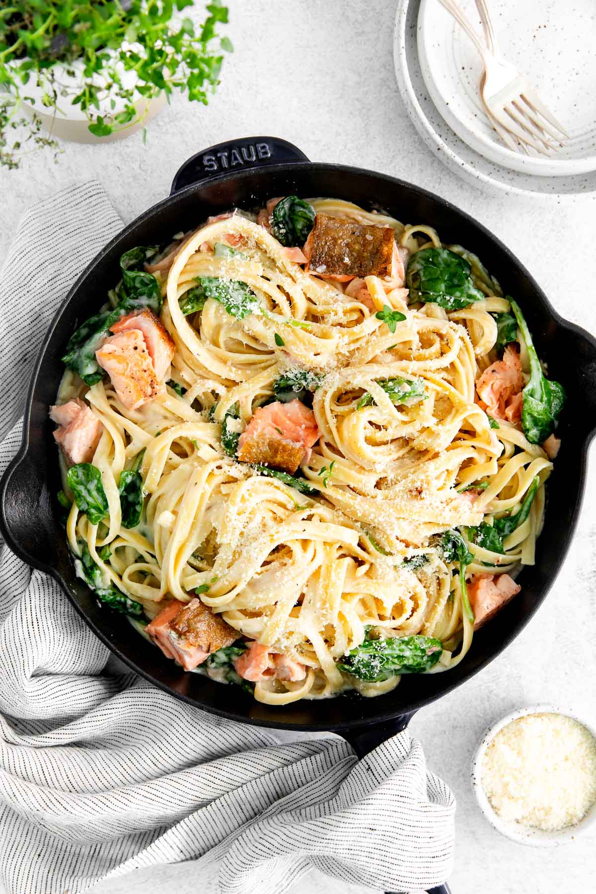 A black cast iron pan filled with salmon pasta.