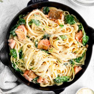 A black cast iron pan filled with salmon pasta.