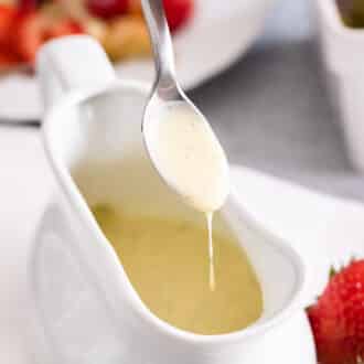 Vanilla sauce dripping from a spoon into a bowl.