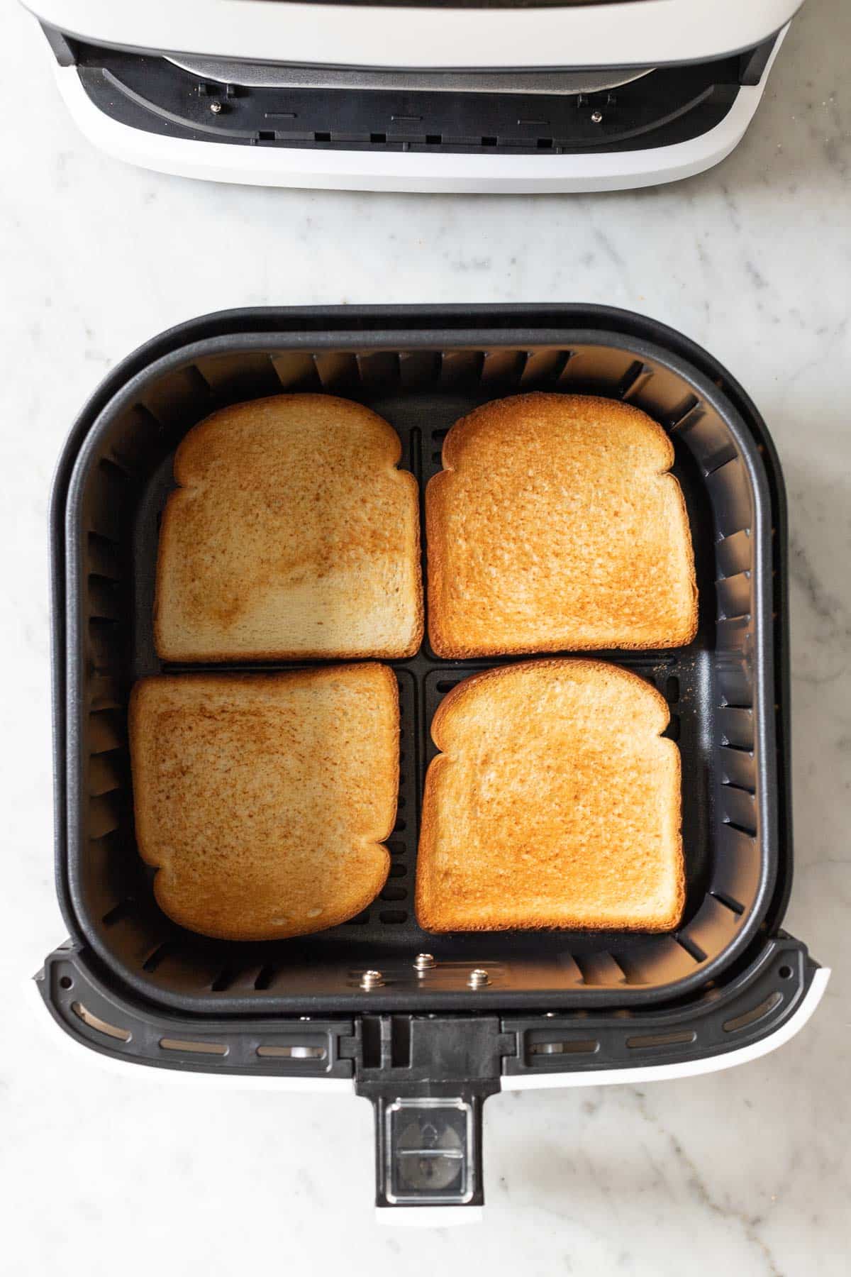 Toasted bread in an Air Fryer basket.