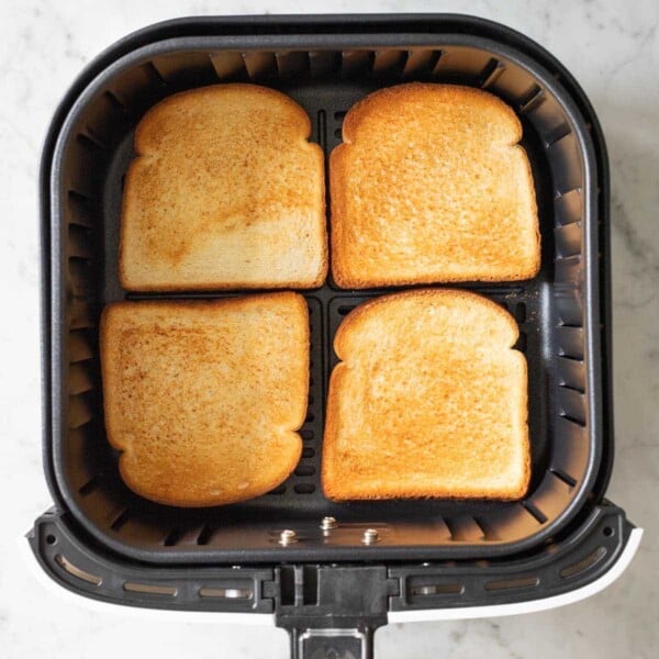 Toasted bread in an Air Fryer basket.