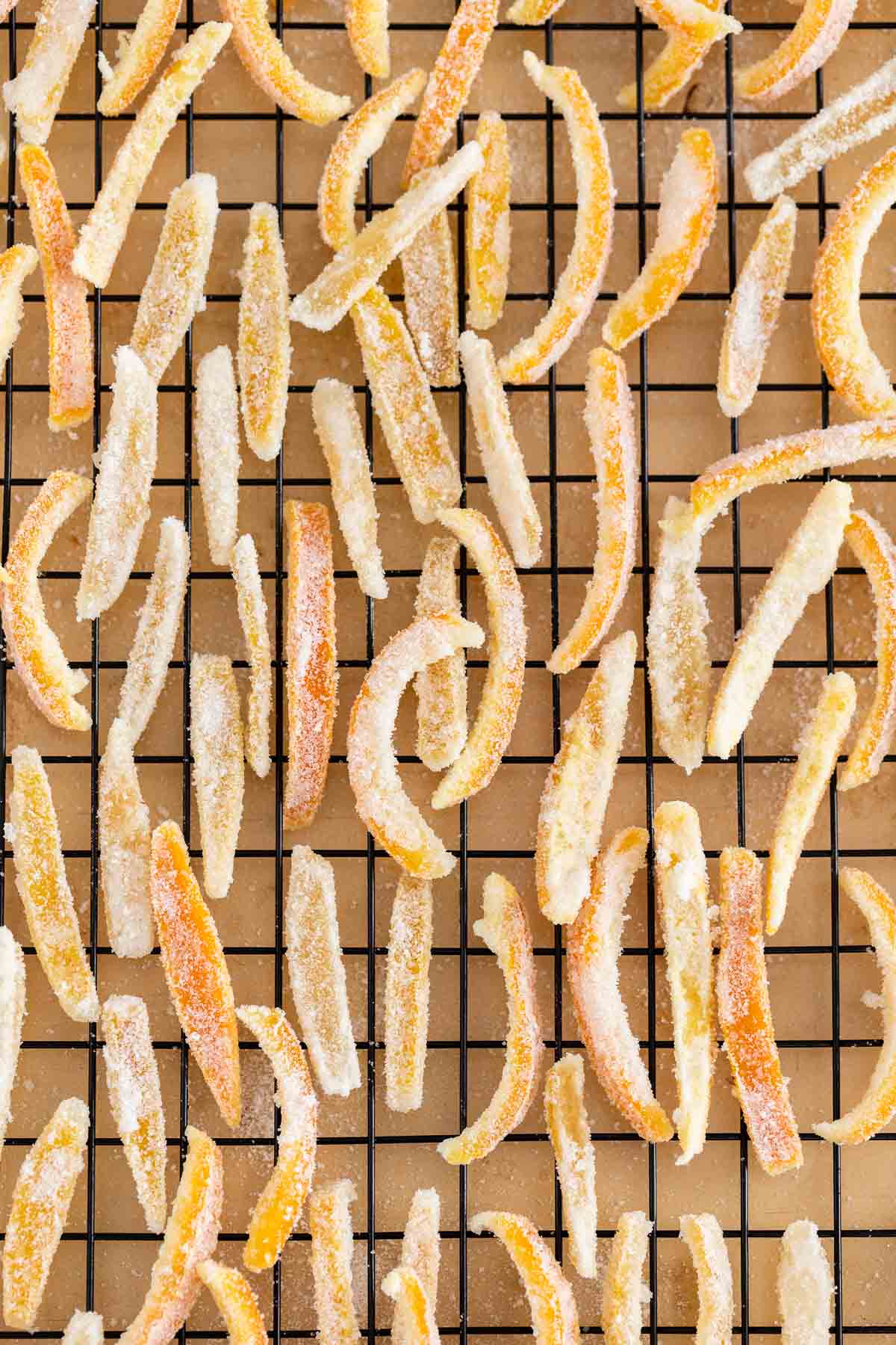 Many stripes of candied peel on a cooling rack.
