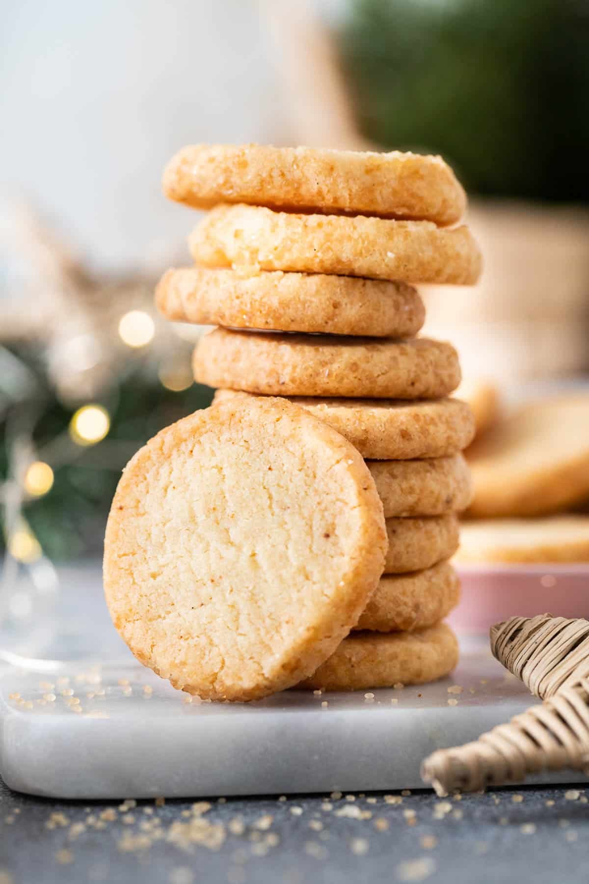 A stack of German shortbread cookies with a cookie leaning on it.