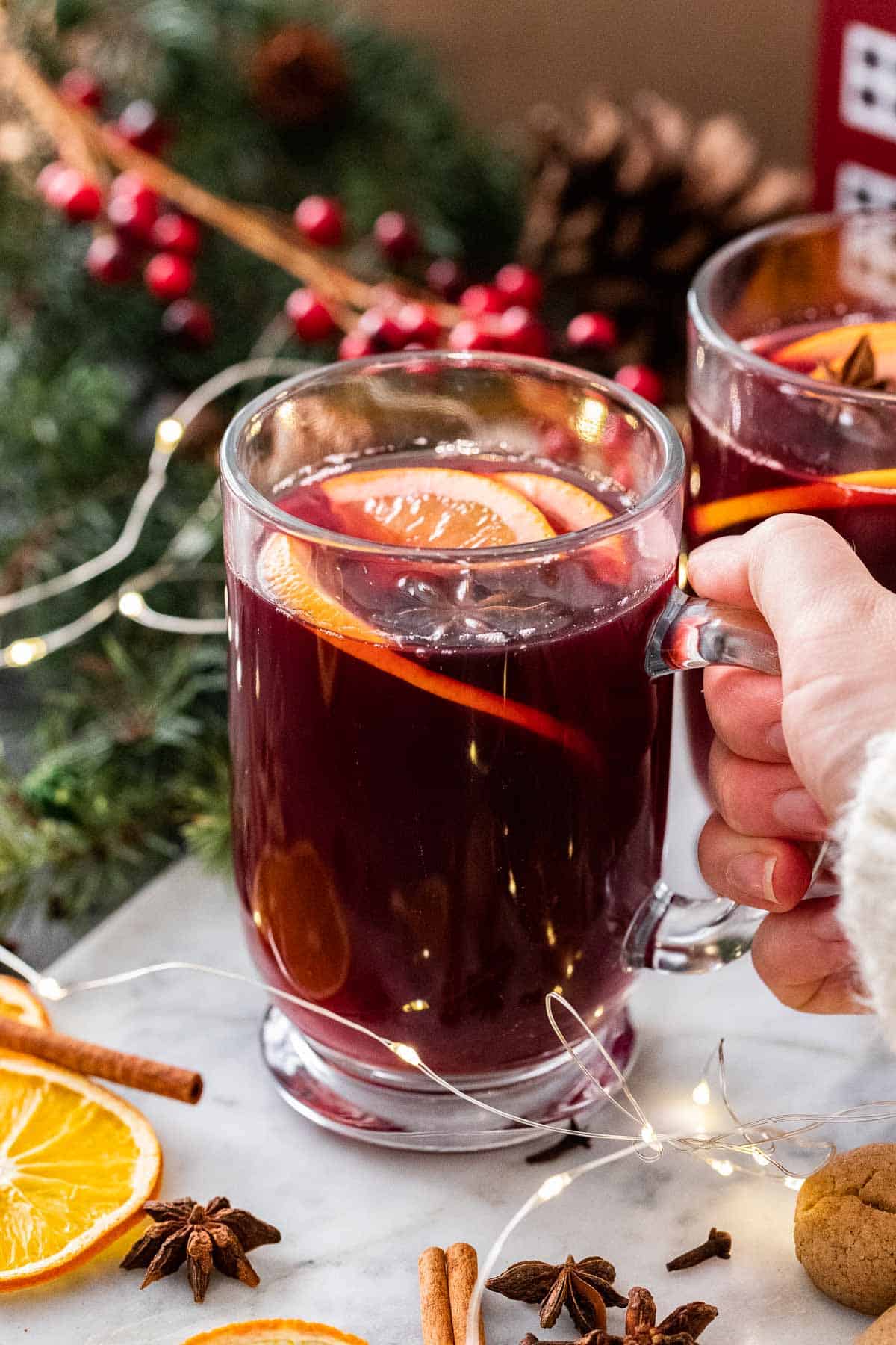 A hand holding a mug of mulled wine.