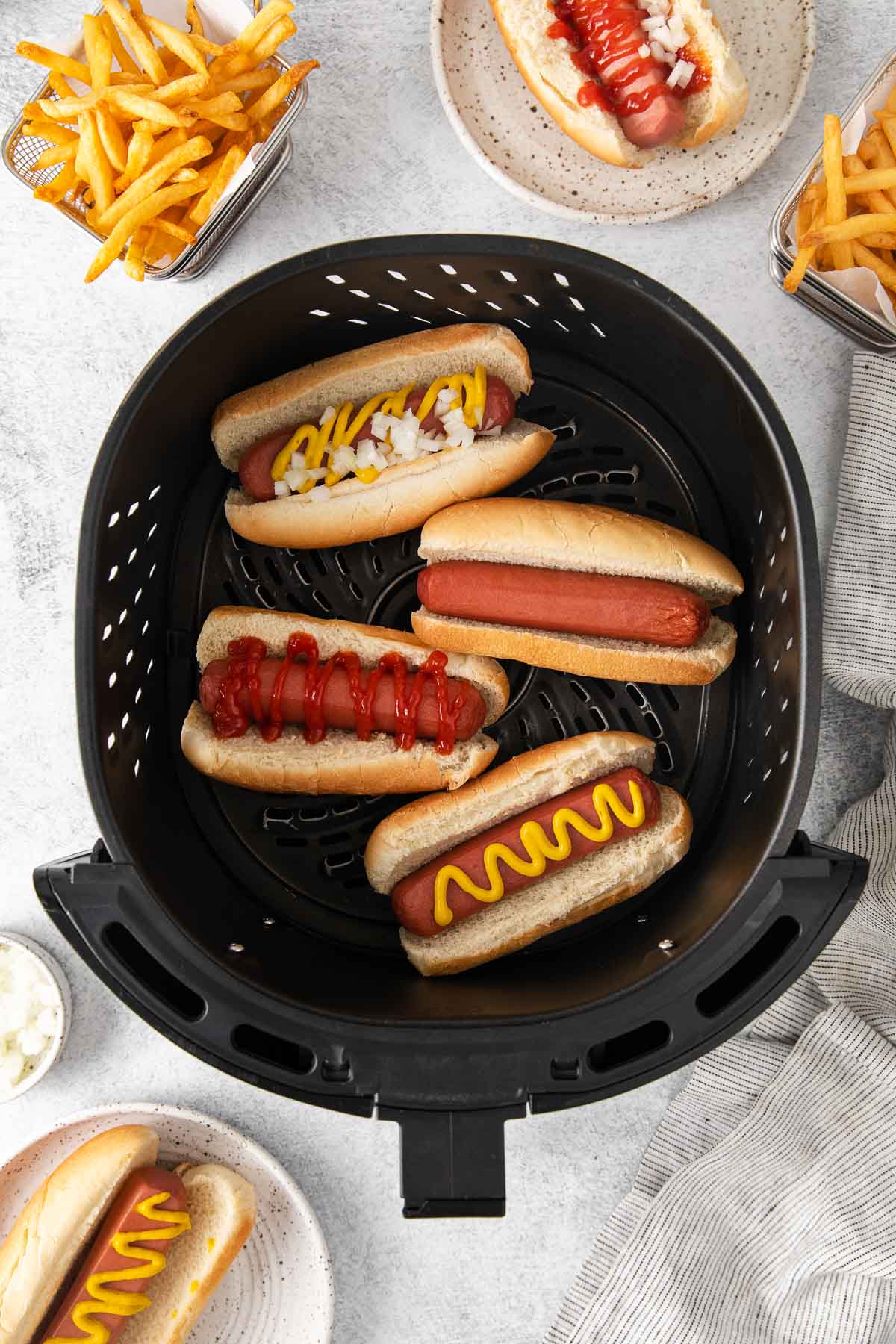 Hot Dogs in an air fryer basket.