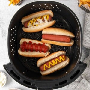 Hot Dogs in an air fryer basket.