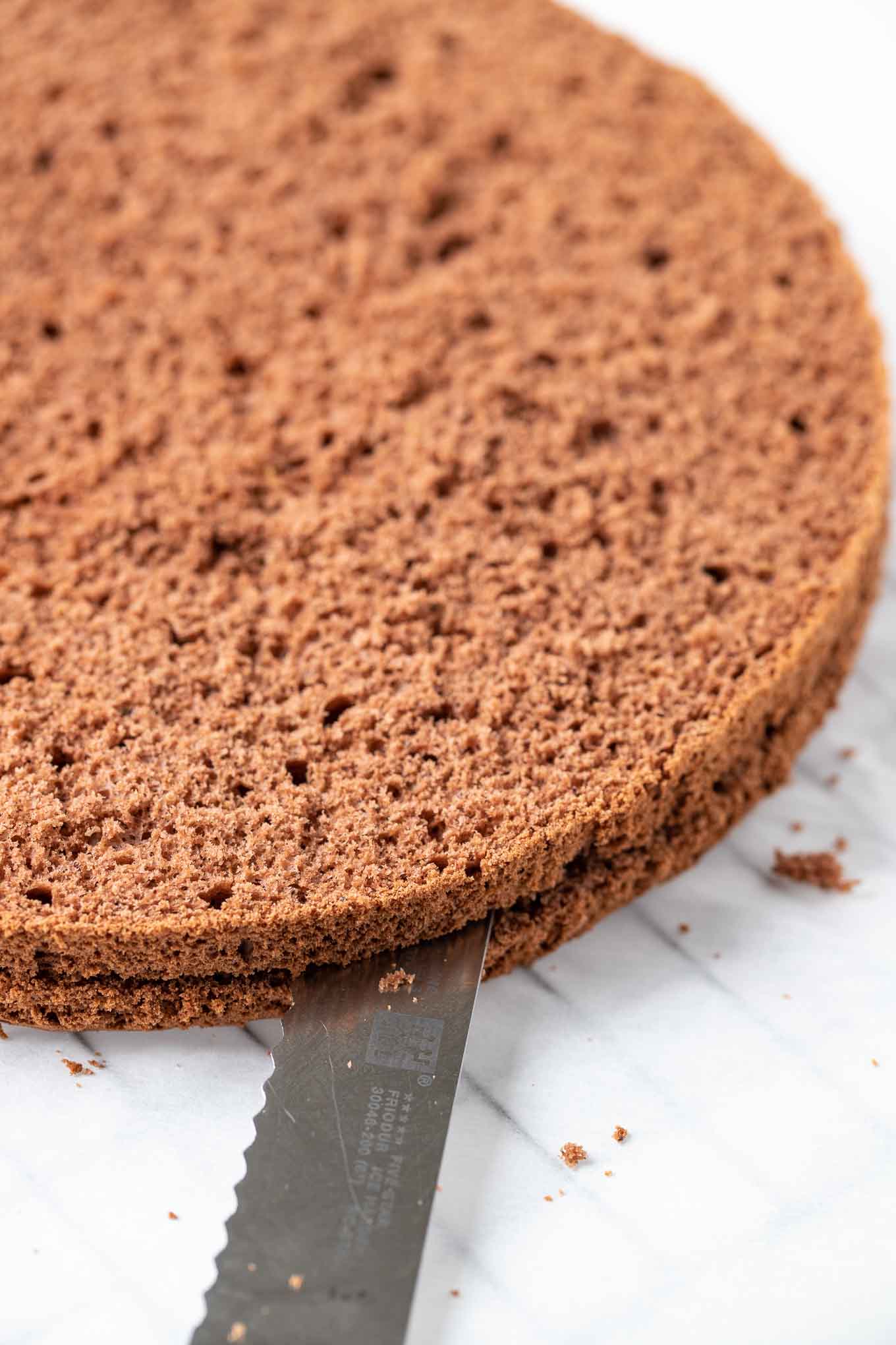 Cake being cut with a serrated knife.