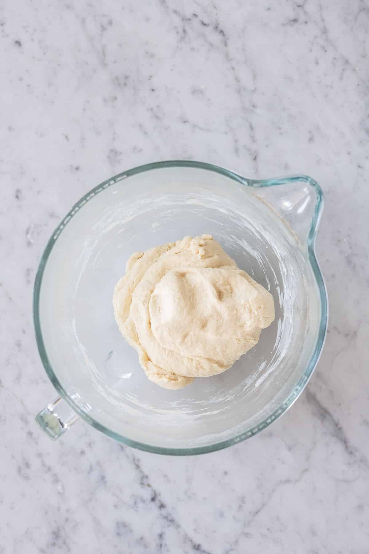 Yeast dough in a glass bowl.