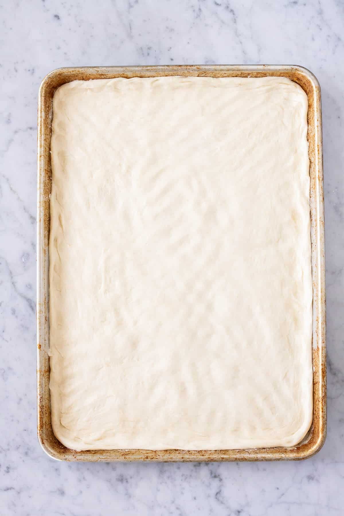 Dough rolled out on a baking sheet.