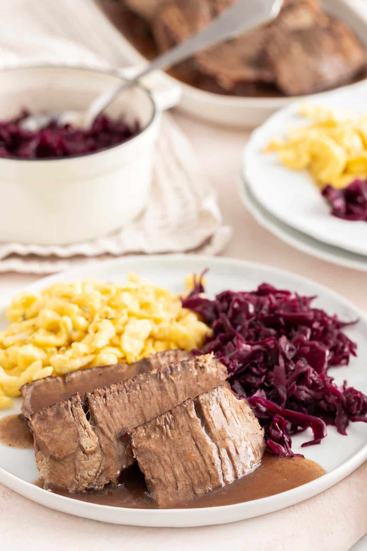 The finished roast served on a plate with sides.