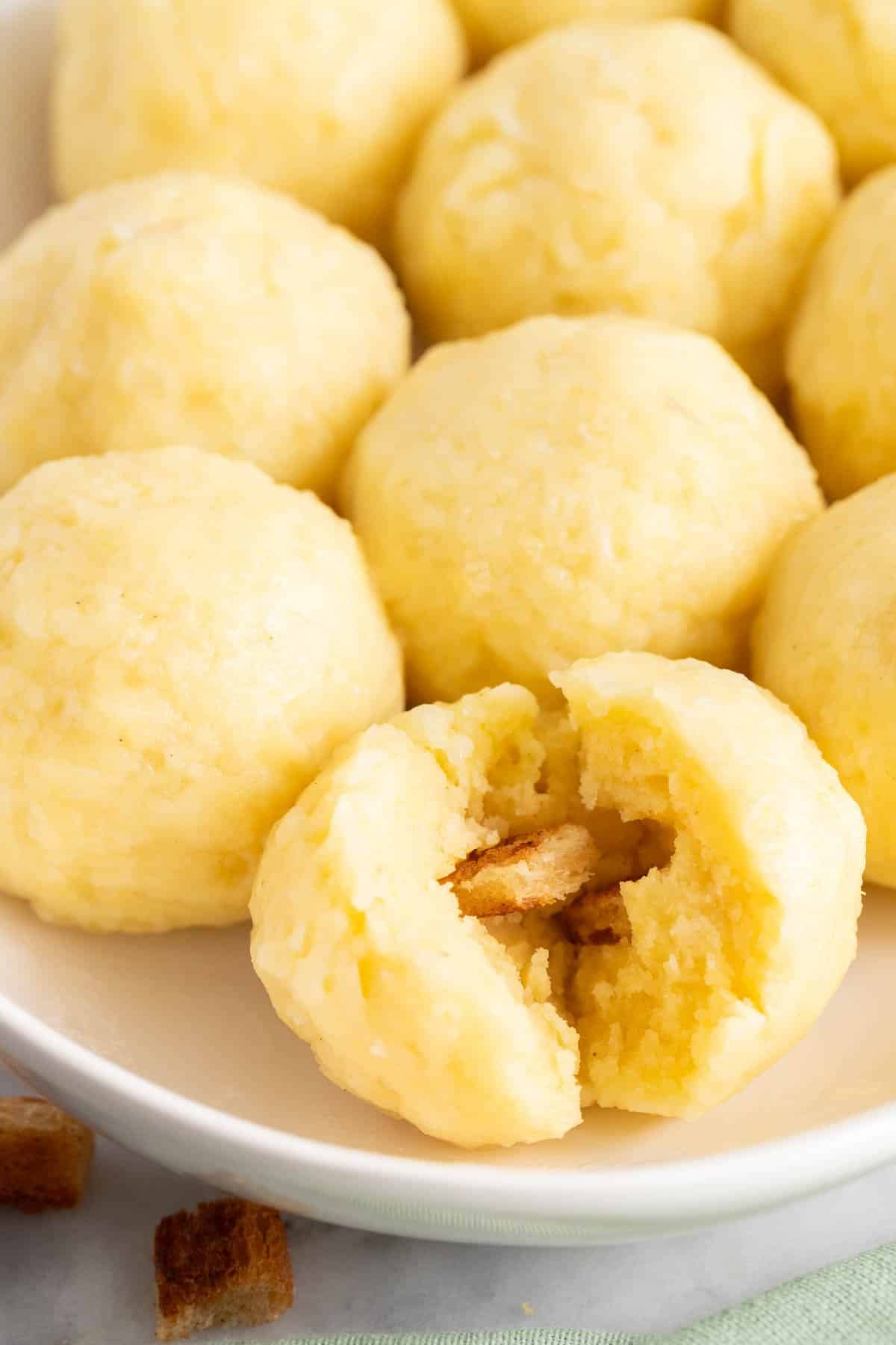 A ripped-open potato dumpling on a serving dish.