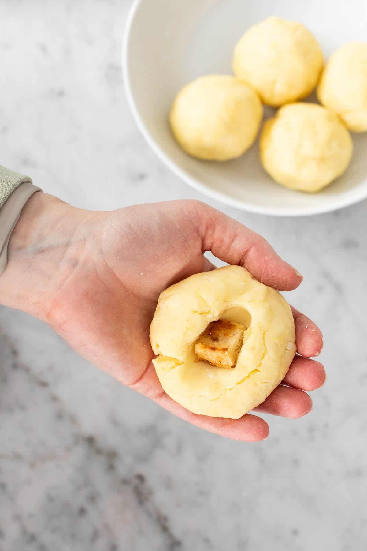 Adding bread into potato dumpling.