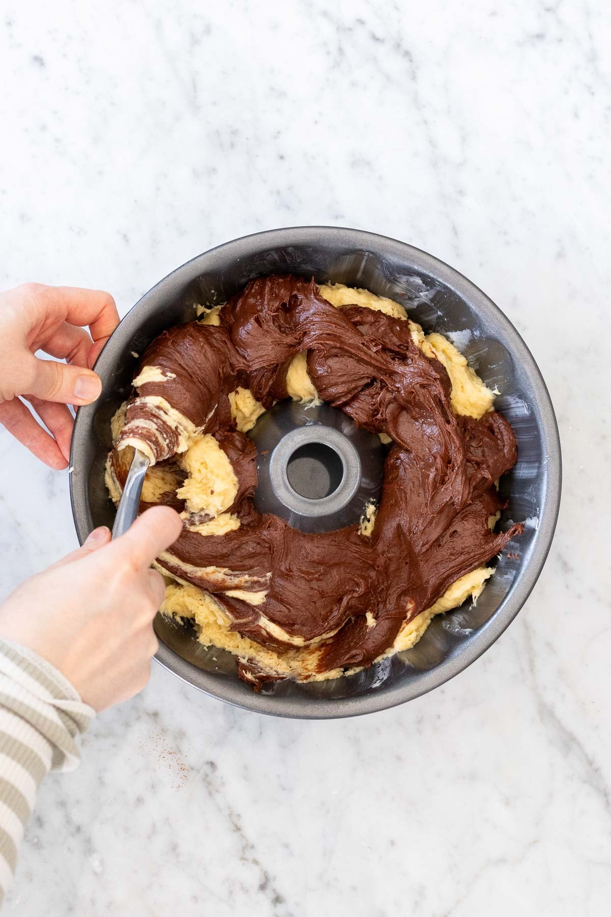 Swirling marble cake batter with a fork.