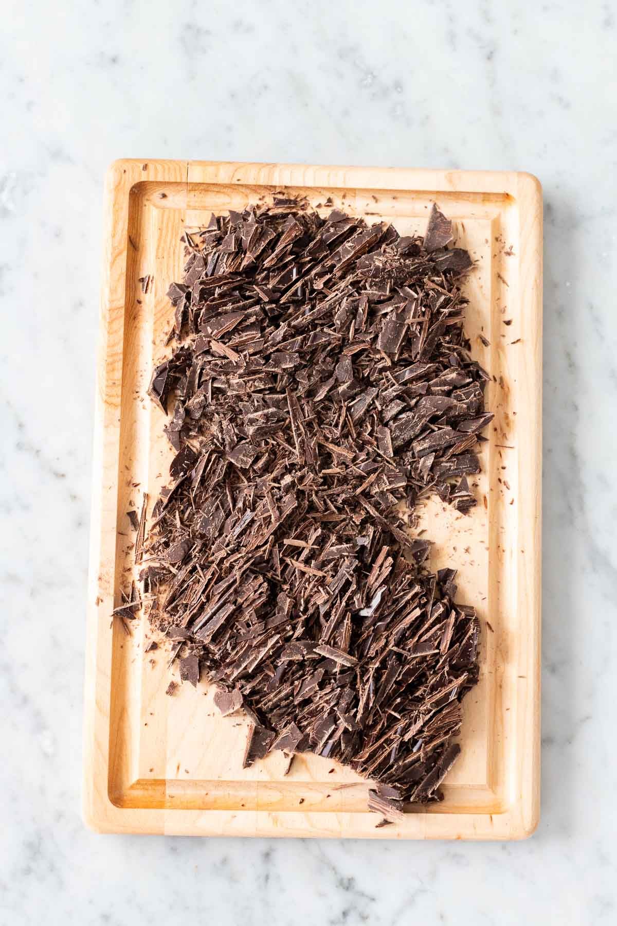 Chopped chocolate on a cutting board.