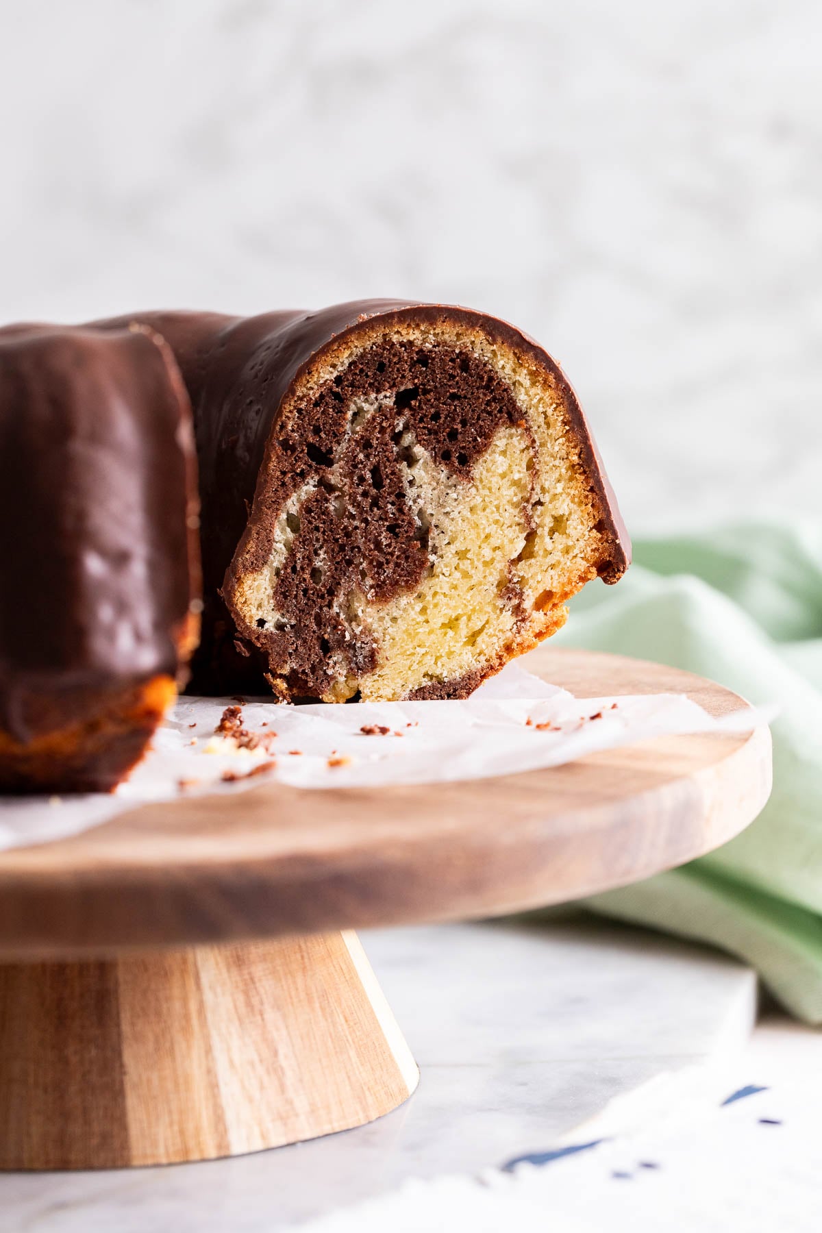 A marble bundt cake on a wooden cake stand.